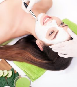 Hardware cosmetology. Closeup picture of lovely young woman with cream mask in a beauty parlour.