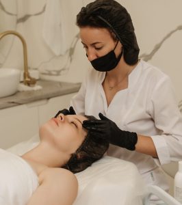 of a qualified massotherapist woman's hands massaging female client facial skin. Beauty treatment concept